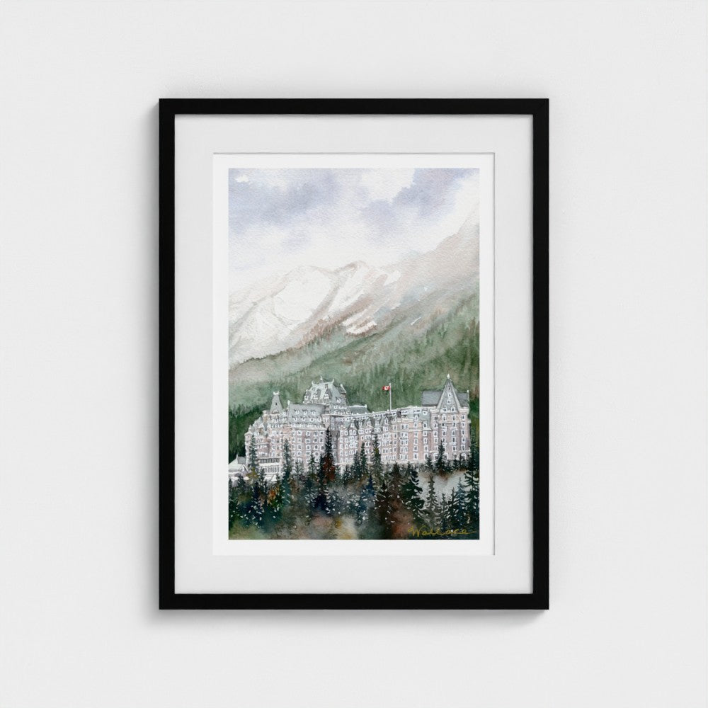 Framed artwork of a mountain landscape with the Banff Springs Hotel amongst the misty trees.